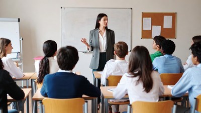 Teacher lecturing diverse students in classroom