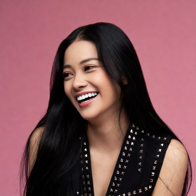 Asian woman smiling on pink background