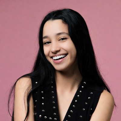 Smiling young woman in black studded top