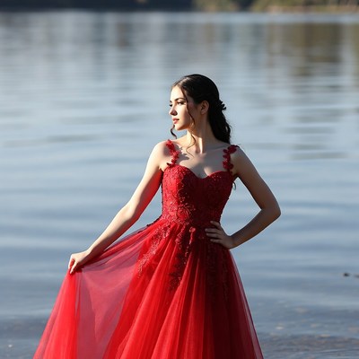 Woman in red gown by lake