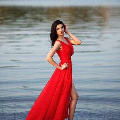 Woman in red dress by lake