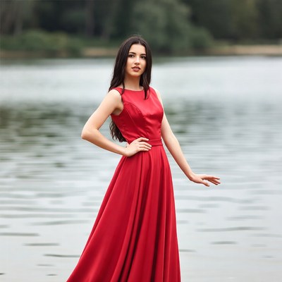 Woman in red dress by lake