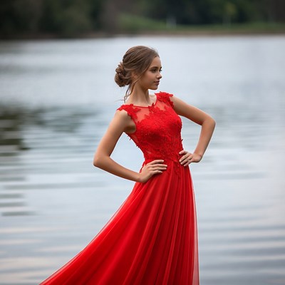 Woman in red lace gown by lake