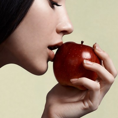 Asian woman biting red apple