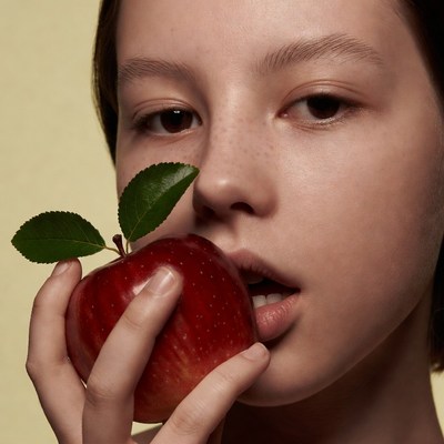 Asian girl biting red apple