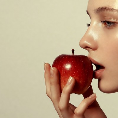 Woman biting red apple