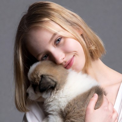 Woman hugging fluffy Samoyed puppy