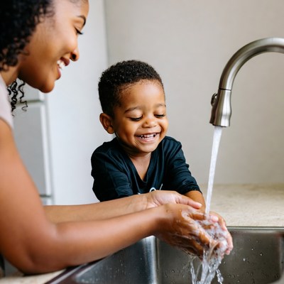 African-American mother and toddler washing hands