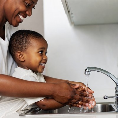 African-American mother teaching toddler handwashing
