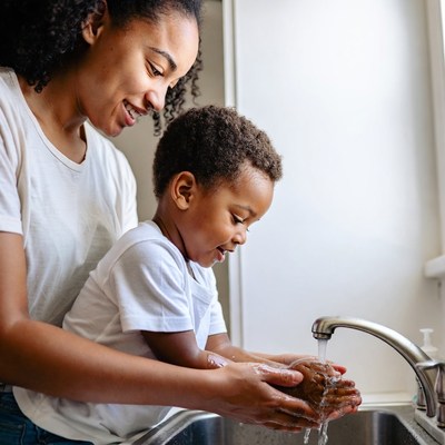 African-American mother teaching toddler handwashing