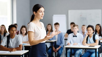 Female teacher lecturing diverse classroom students