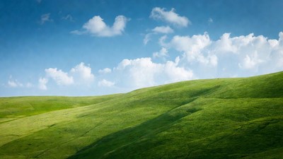 Green rolling hills under blue sky