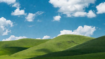 Green rolling hills under blue sky
