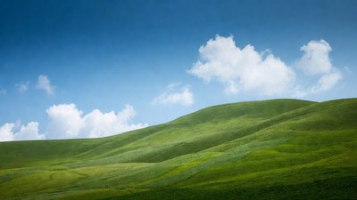 Green rolling hills under blue sky