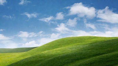 Green rolling hills under blue sky