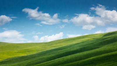 Green rolling hills under blue sky