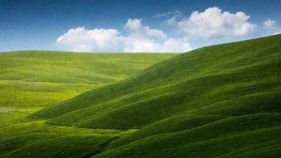Rolling Green Hills Under Blue Sky