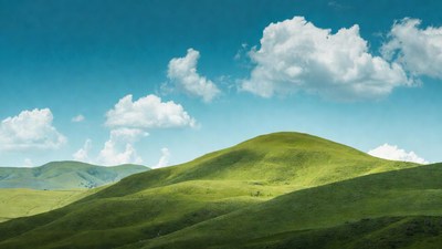 Green rolling hills under blue sky