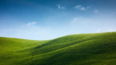 Green rolling hills under blue sky