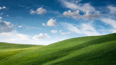 Green rolling hills under blue sky