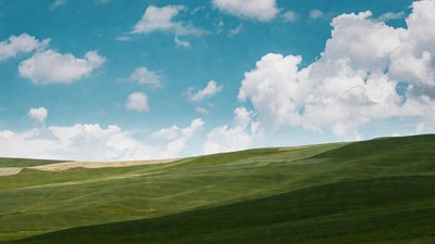 Green rolling hills under blue sky
