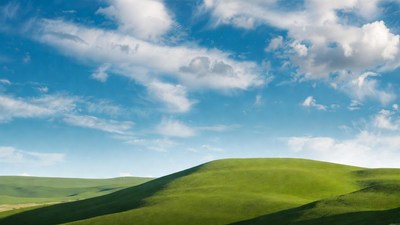 Green rolling hills under blue sky