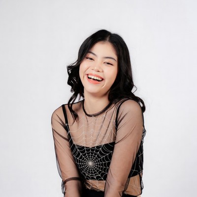 Asian woman in spiderweb top smiling