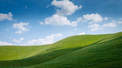 Rolling Green Hills Under Blue Sky