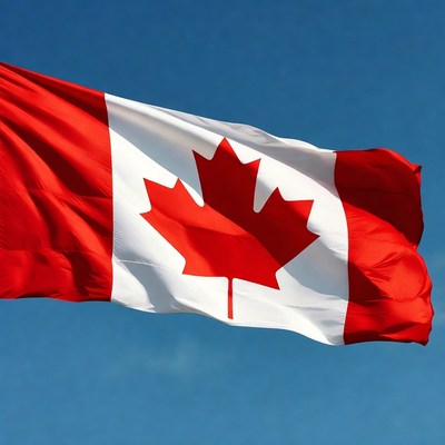 Canadian Flag Waving Against Blue Sky