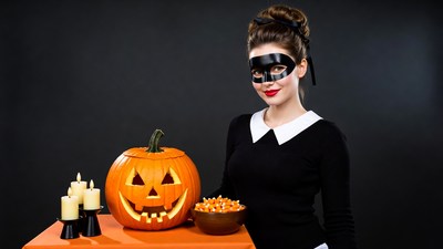 Woman in black mask holding candy bowl