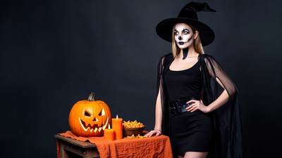 Woman in witch makeup with pumpkin
