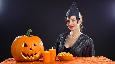 Woman in witch costume with jack-o-lantern