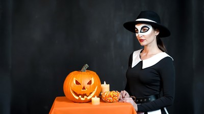 Woman in nun costume with jack-o-lantern