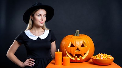 Woman in witch hat with jack-o-lantern