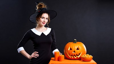 Woman in witch costume with jack-o-lantern