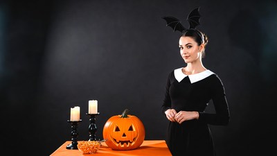 Woman in black dress with jack-o-lantern