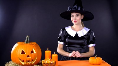Woman in witch costume with jack-o-lantern