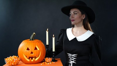 Woman in witch costume with jack-o-lantern
