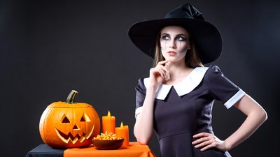 Woman in Witch Costume with Pumpkin