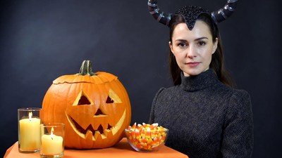 Woman with devil horns and jack-o-lantern