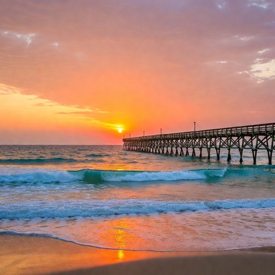 Sunset over pier and ocean waves