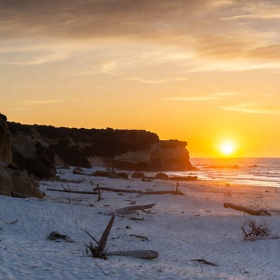 Sunset over white sand beach cliffs