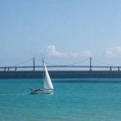 Sailboat in front of suspension bridge