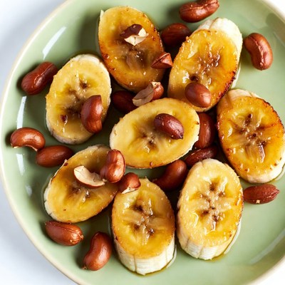 Bananas with peanuts on green plate