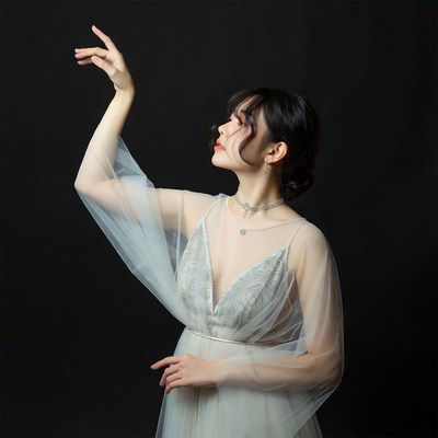 Asian woman in sheer gown posing gracefully