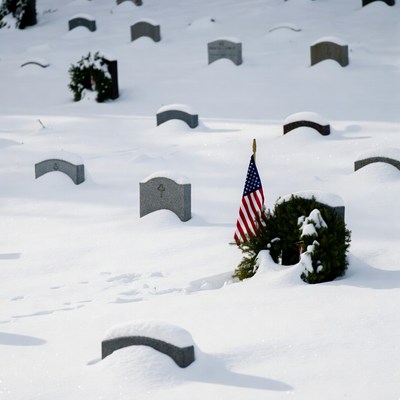 American flag on snowy gravestone