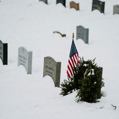 American flag on snowy gravestone