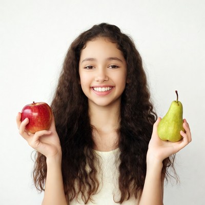 Girl holding red apple and green pear