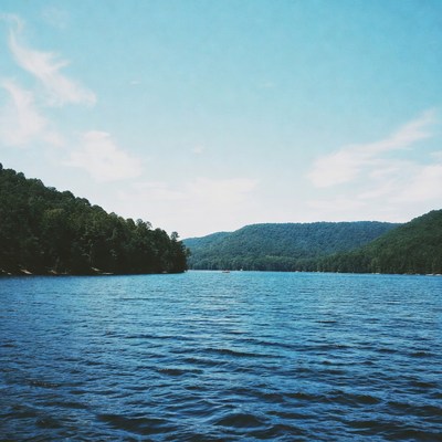 Serene Lake Surrounded by Forested Mountains