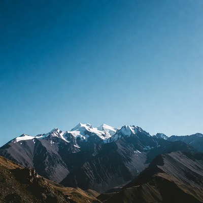 Snowy Mountain Peaks Under Blue Sky